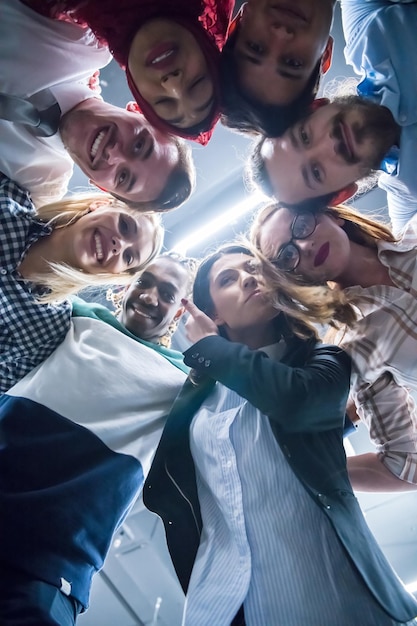 Gruppo multietnico di giovani uomini d'affari che celebrano il successo nei loro luoghi di lavoro nel successo dell'ufficio di avvio e concetto vincente