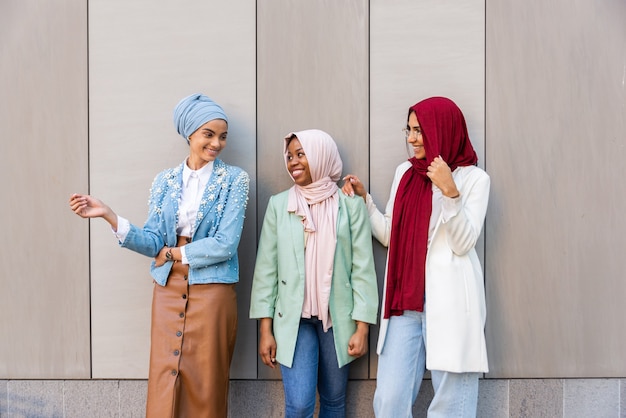 Gruppo multietnico di ragazze musulmane che indossano abiti casual e tradizionali legami con l'hijab