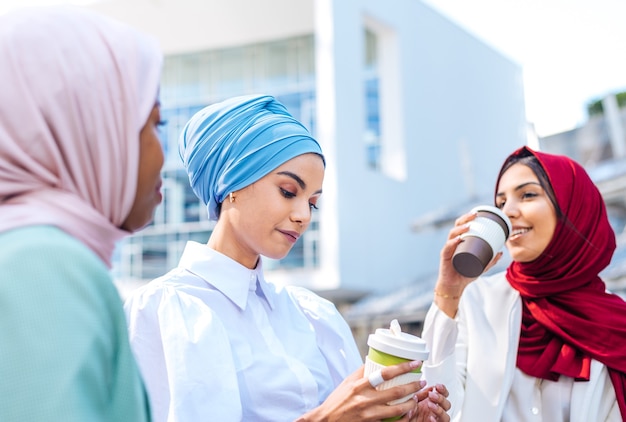 Gruppo multietnico di ragazze musulmane che indossano abiti casual e tradizionali legami hijab e si divertono all'aperto - 3 ragazze arabe