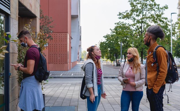 Gruppo multietnico di studenti universitari in fila per presentare le iscrizioni annuali la nuova vita normale durante il periodo epidemico prevenzione dal contagio indossando mascherine