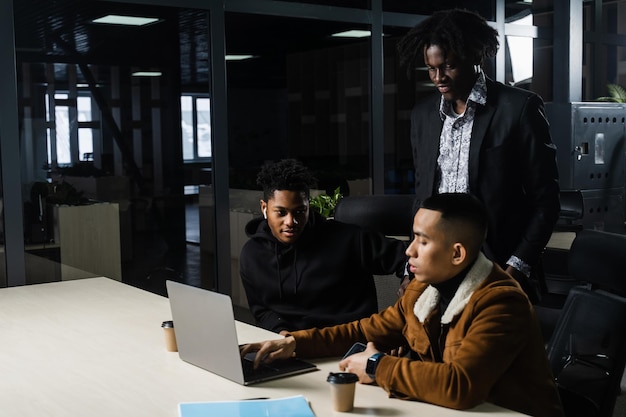 Gruppo multinazionale di brainstorming di colleghi che lavorano online su progetto nella sala riunioni Uomo d'affari africano nero e asiatico lavorano in squadra insieme
