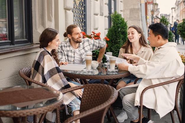 Gruppo multirazziale di amici che bevono un caffè insieme in un caffè all'aperto