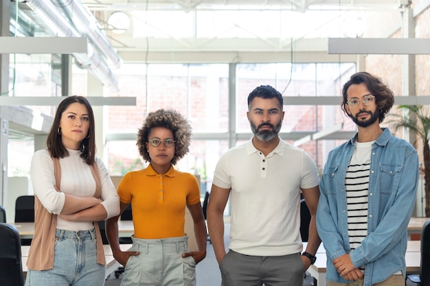 Gruppo multirazziale di colleghi che guardano la telecamera Giovani imprenditori nello spazio di coworking Start up