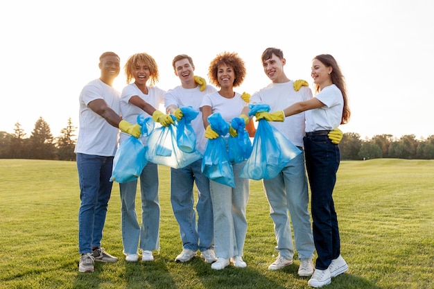 gruppo multirazziale di volontari in guanti con sacchetti della spazzatura raccolgono spazzature e plastica
