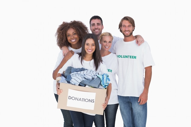 Gruppo sorridente di volontari che tengono la scatola di donazione