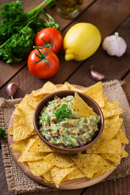 Guacamole avocado, lime, pomodoro, cipolla e coriandolo, servito con nachos - spuntino messicano tradizionale