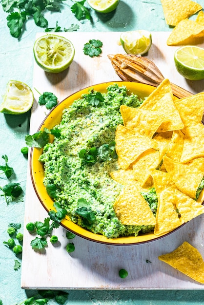 Guacamole di piselli verdi con nachos Cibo per feste sano alternativo all'avocado