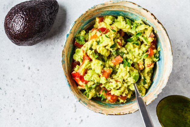 Guacamole di pomodoro fresco di avocado in una ciotola Concetto di cibo basato sulla pianta sana