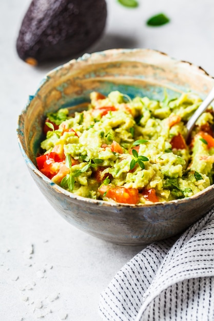 Guacamole di pomodoro fresco di avocado in una ciotola Concetto di cibo basato sulla pianta sana