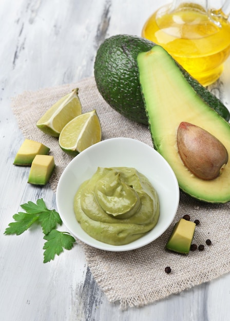 Guacamole fresco in una ciotola sul tavolo di legno