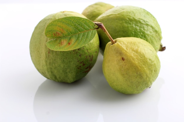 Guaiava affettata fresca e foglie (jambu biji merah) o Psidium guajava, isolato su bianco. Può migliorare l'immunità corporea, abbassare la pressione sanguigna e il colesterolo, avviare il tratto digestivo e ricco di vitamina C.