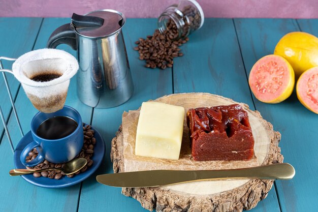 Guaiava dolce con formaggio su una tavola di legno accanto a una tazza di coltello e chicchi di caffè