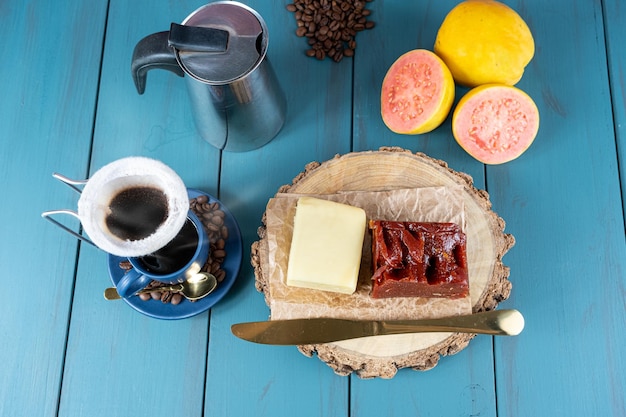 Guaiava dolce con formaggio su una tavola di legno accanto a una tazza di coltello e una vista di chicchi di caffè