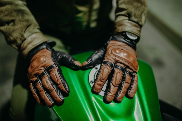 guanti da moto in pelle marrone sul serbatoio di una moto