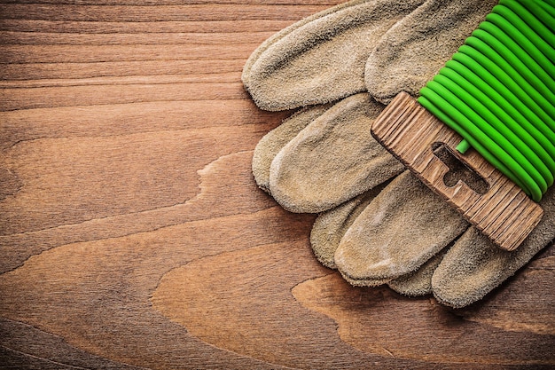 Guanti di sicurezza in pelle con filo da giardino su tavola di legno concetto di giardinaggio