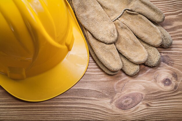 Guanti protettivi in pelle per casco da costruzione su tavola di legno