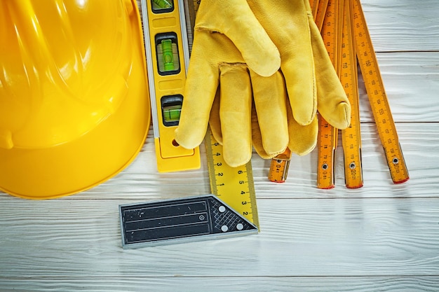 Guanti protettivi livello di costruzione in legno metro edificio casco su tavola di legno