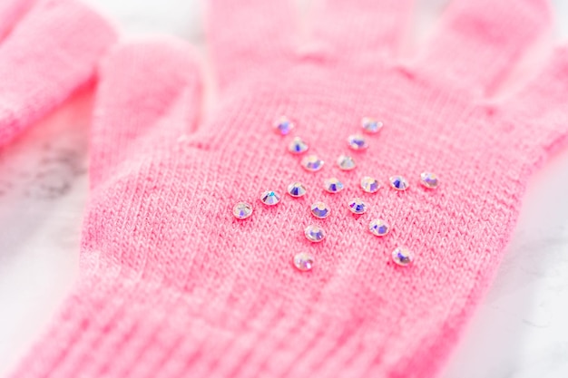 Guanti rosa per bambini con strass a forma di fiocco di neve.