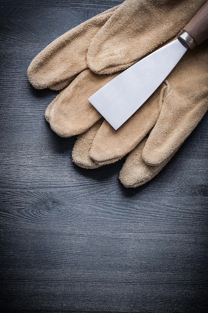 Guanto da lavoro raschietto per vernice versione verticale tavola in legno scuro