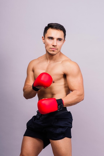 Guantoni da boxe uomo che si allena nella sfida di lotta sportiva o nella competizione mma sullo sfondo dello studio