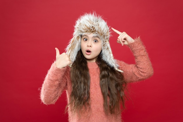 Guarda questo cappello caldo per il freddo Cappello da indossare per ragazza con paraorecchie sfondo bianco Accessorio morbido in pelliccia Indumenti in pelliccia premurosi Cappello morbido per capelli lunghi per bambini goditi la morbidezza Concetto di moda invernale