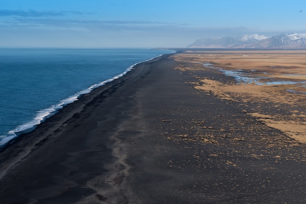 Guardando a ovest da Dyrholaey alla vasta spiaggia di sabbia nera vulcanica con montagne