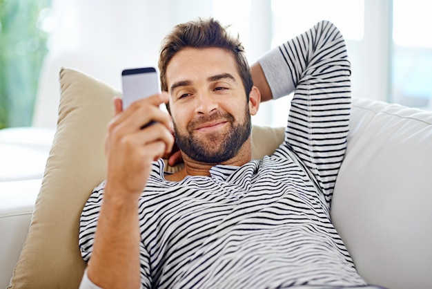 Guardando attraverso le sue opzioni Uomo che guarda il suo cellulare a casa