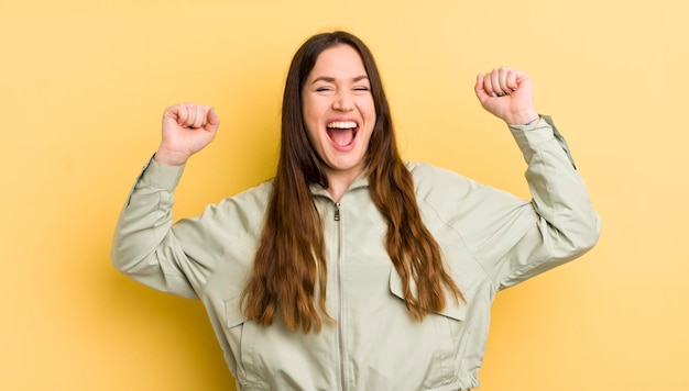 guardando estremamente felice e sorpreso che celebra il successo gridando e saltando