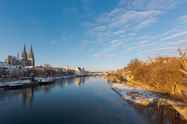 Guardando giù sui pilastri del frangiflutti con la neve e il Danubio dal ponte di pietra a Regensburg