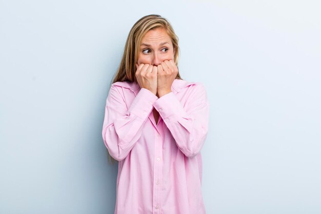 Guardando preoccupato, ansioso, stressato e impaurito, mangiarsi le unghie e guardare lo spazio laterale della copia