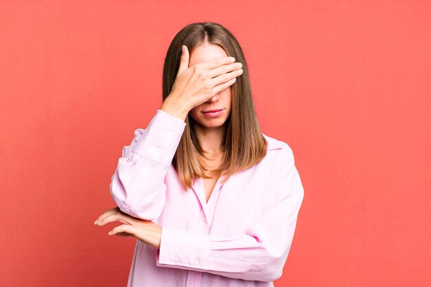 Guardando stressato vergognoso o sconvolto con un mal di testa che copre il viso con la mano