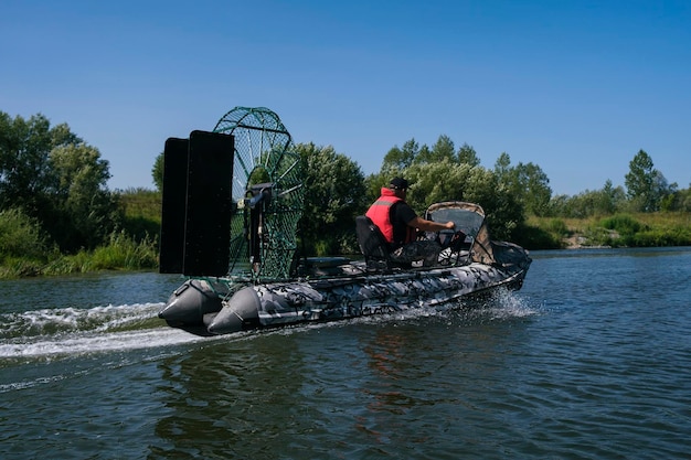 Guida ad alta velocità in un airboat sul fiume in una giornata estiva con spruzzi e onde