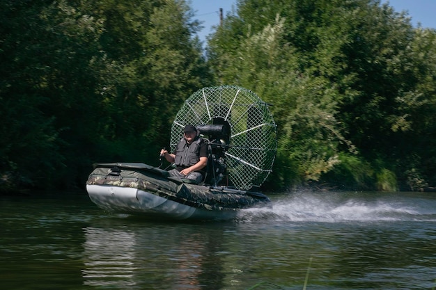 Guida ad alta velocità in un airboat sul fiume in una giornata estiva con spruzzi e onde