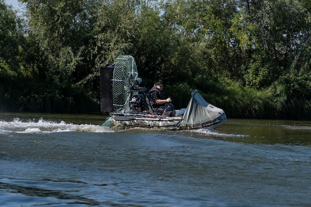 Guida ad alta velocità in un airboat sul fiume in una giornata estiva con spruzzi e onde