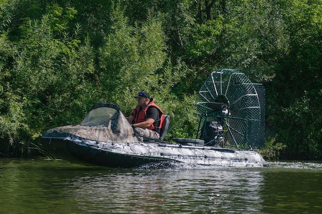 Guida ad alta velocità in un airboat sul fiume in una giornata estiva con spruzzi e onde