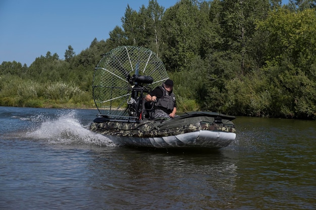 Guida ad alta velocità in un airboat sul fiume in una giornata estiva con spruzzi e onde