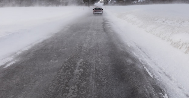 Guida di veicoli nella bufera di neve di inverno sulla strada nevosa in Norvegia