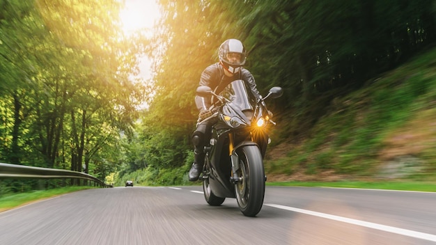 Guida in moto sulla strada forestale che guida su una strada vuota in un copyspace per il tour in moto per il tuo testo individuale