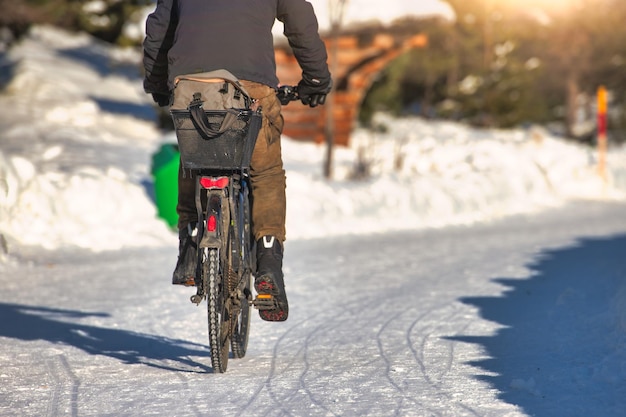 Guida la tua bicicletta su una strada innevata in inverno