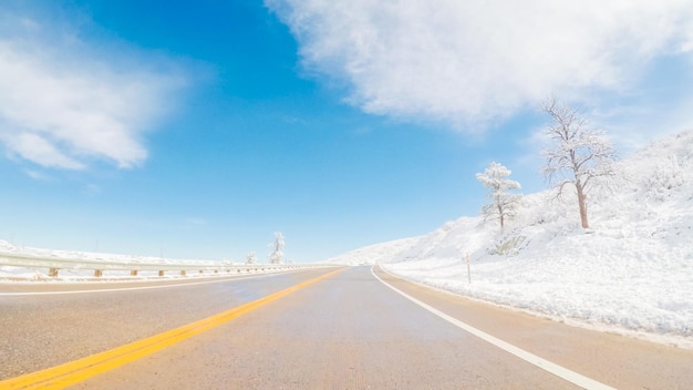 Guidando su strada suburbana dopo la tempesta di neve primaverile.