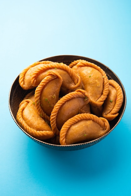 Gujiya o gujia o karanji. gnocchi dolci fatti durante la festa di holi e diwali, serviti in un piatto