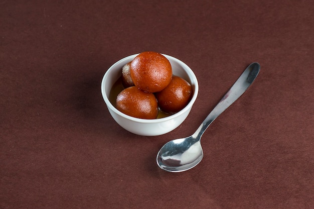 Gulab Jamun, dessert indiano o piatto dolce in ciotola con cucchiaio