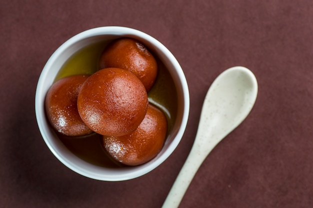 Gulab Jamun, dessert indiano o piatto dolce in una ciotola con un cucchiaio