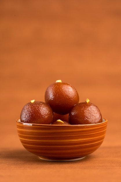 Gulab Jamun in ciotola sulla tavola di legno. Dessert indiano o piatto dolce.