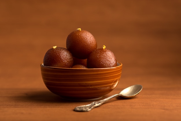 Gulab Jamun in ciotola sulla tavola di legno. Dessert indiano o piatto dolce.