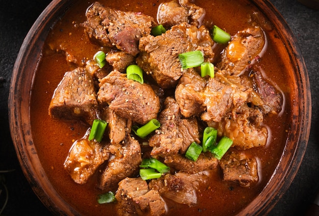 Gulasch, spezzatino di manzo con germogli di pomodoro paprika souce macro, primi piani.