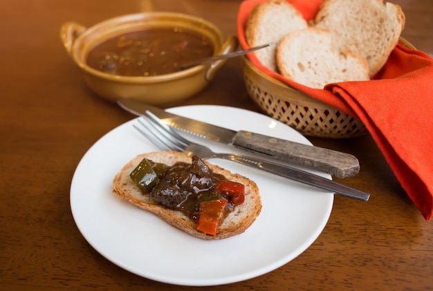 Gulasch ungherese con pane di colore scuro da spezzatino di manzo dal sapore pieno servito.