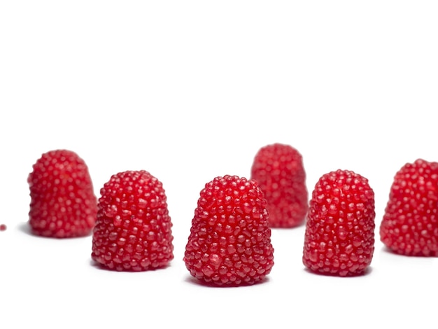 Gummies rossi sotto forma di frutti di bosco Dolci sotto forma di lamponi su sfondo bianco Isolato di marmellata