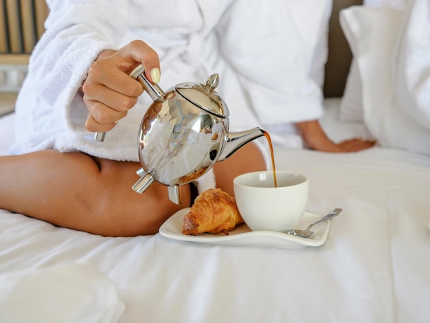 Gustare croissant e caffè in camera da letto