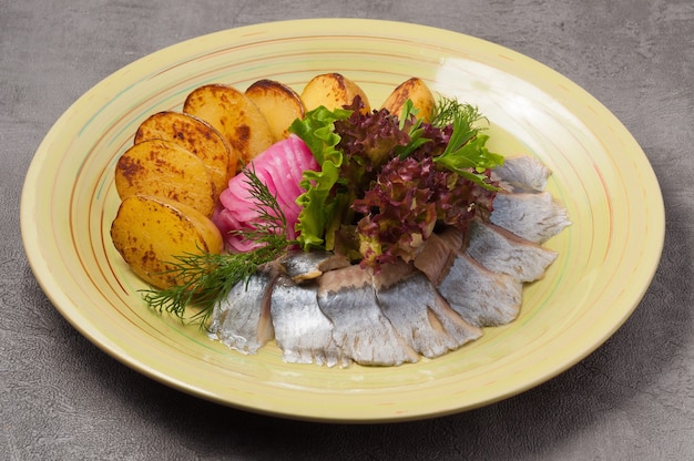 Gustosa aringa salata con patate e cipolle al forno